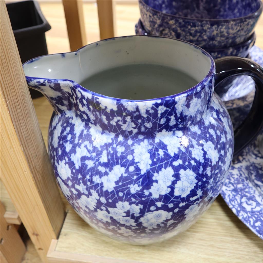 A collection of kitchenwares including a large ironstone jug, 26cm, spongeware bowls, platter, enamel cafeterie, storage jars, cake sta